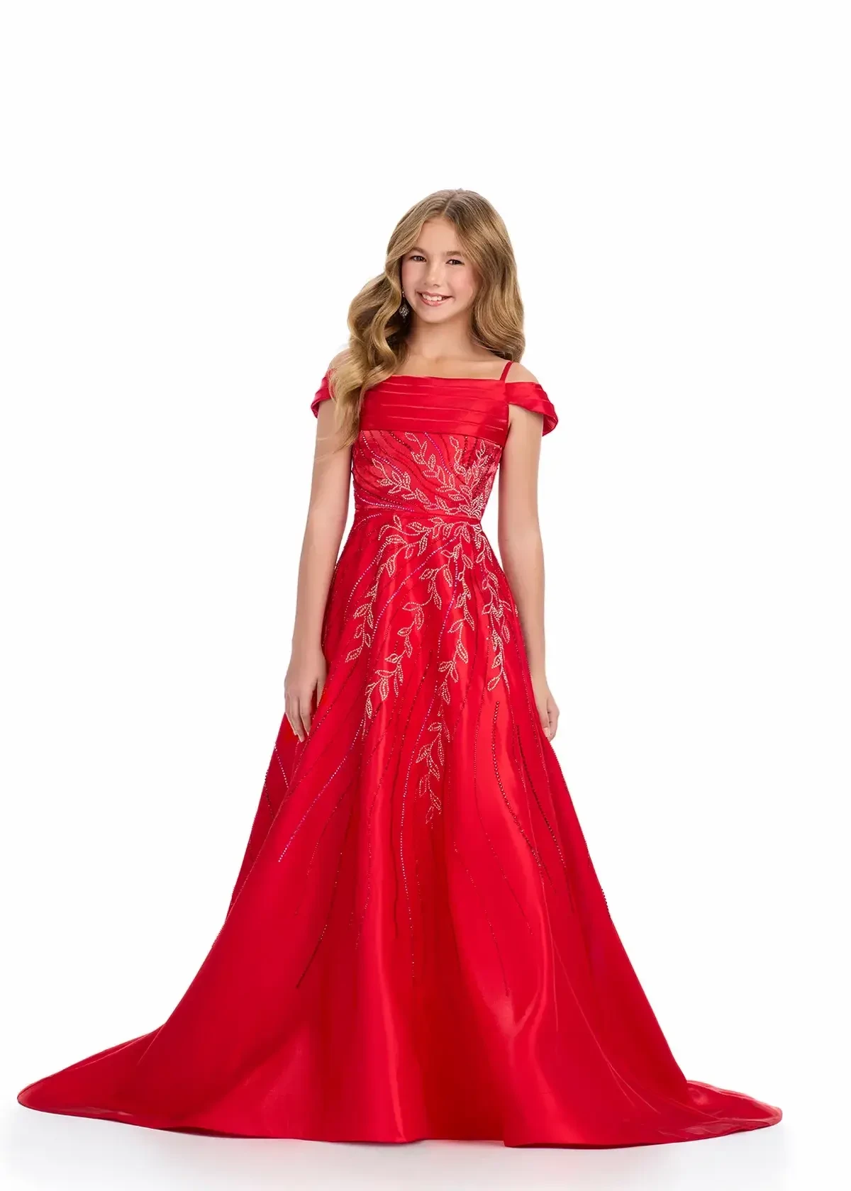 A young girl wearing a red gown with intricate embroidery posing confidently.